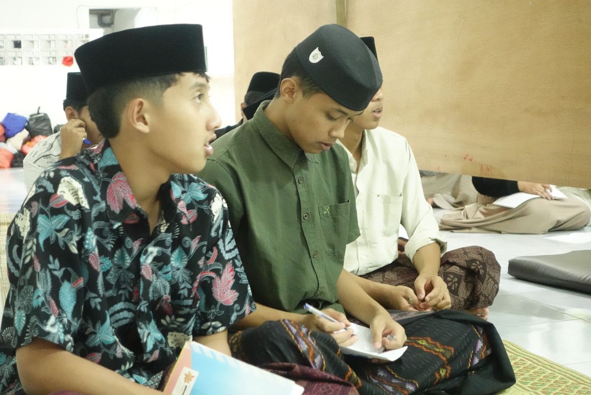 Santri putra mencatat materi